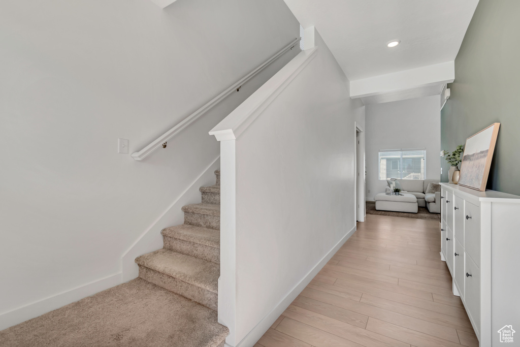 Staircase featuring wood finished floors and recessed lighting