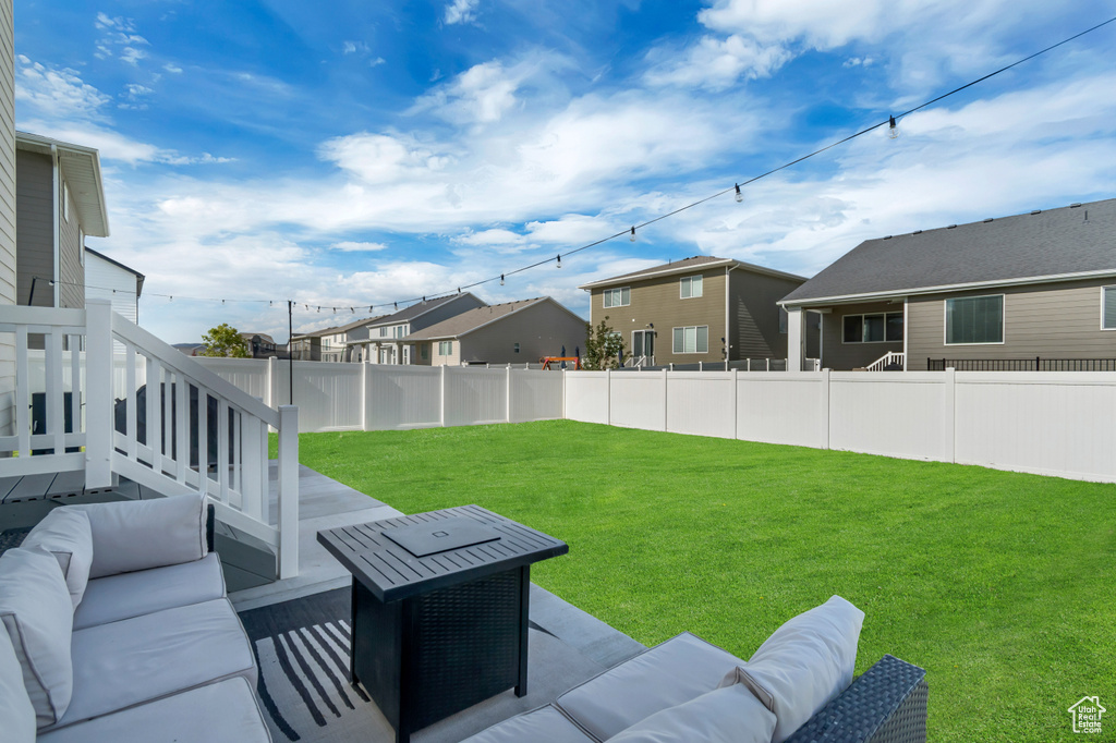 Fenced backyard featuring an outdoor living space, a patio area, and a residential view