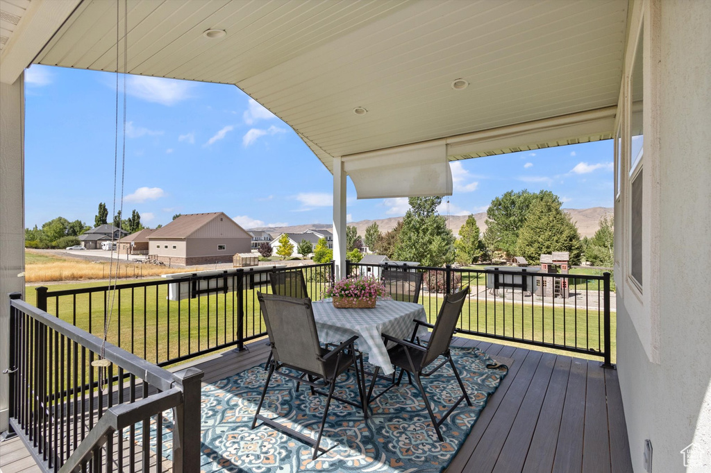 Wooden deck with outdoor dining area, a residential view, and a yard