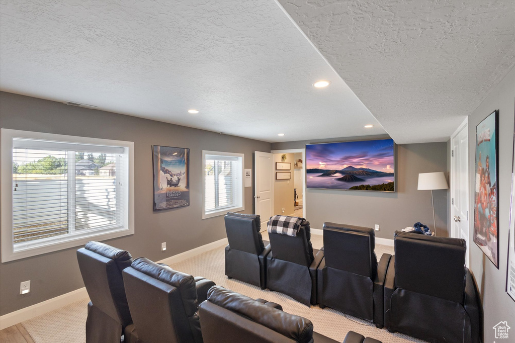 Home theater featuring a textured ceiling, recessed lighting, plenty of natural light, and carpet flooring