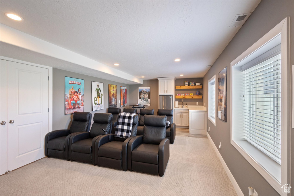 Cinema featuring bar with sink, light carpet, and recessed lighting