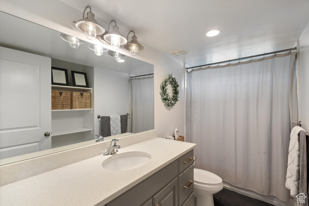 Bathroom featuring vanity, shower / bath combo with shower curtain, and recessed lighting