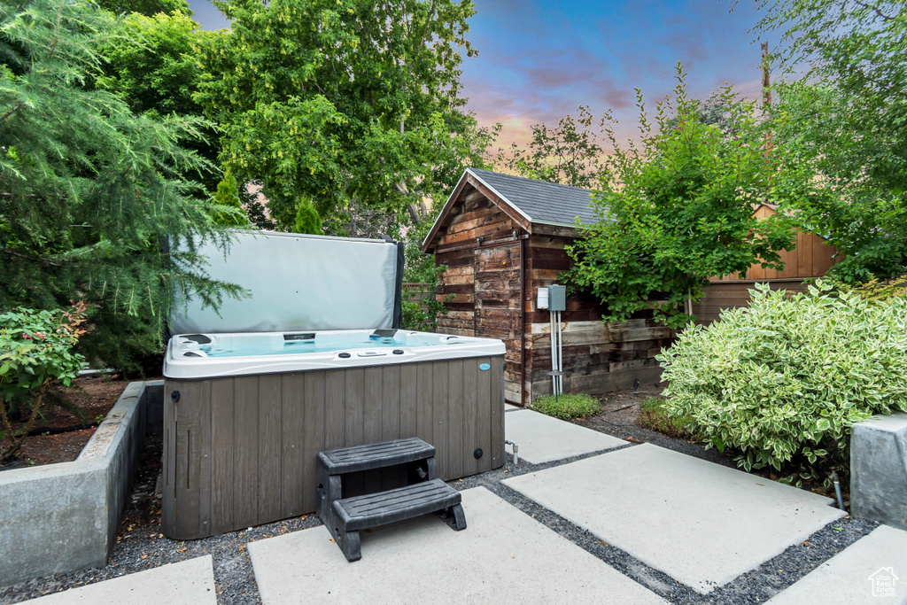 Patio terrace at dusk featuring a hot tub and a patio