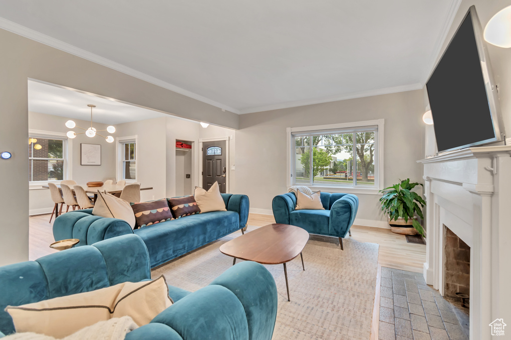 Living area featuring healthy amount of natural light, a fireplace with flush hearth, and crown molding