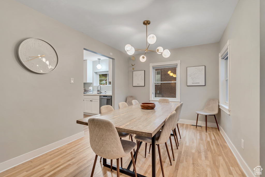 Dining space featuring light wood finished floors and a chandelier