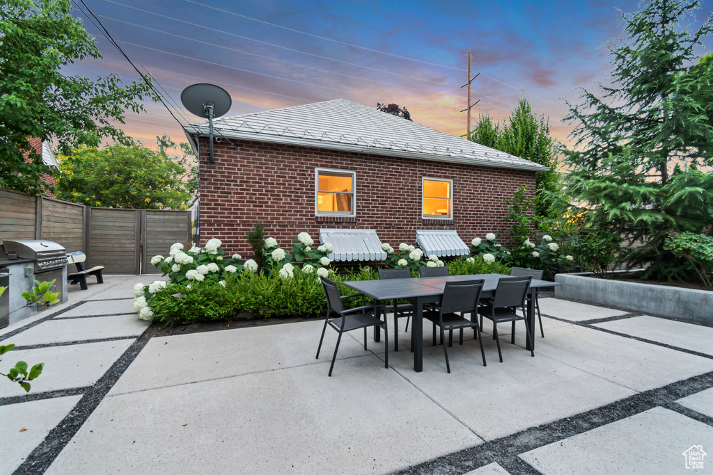 Patio terrace at dusk with outdoor dining space, a patio area, and area for grilling