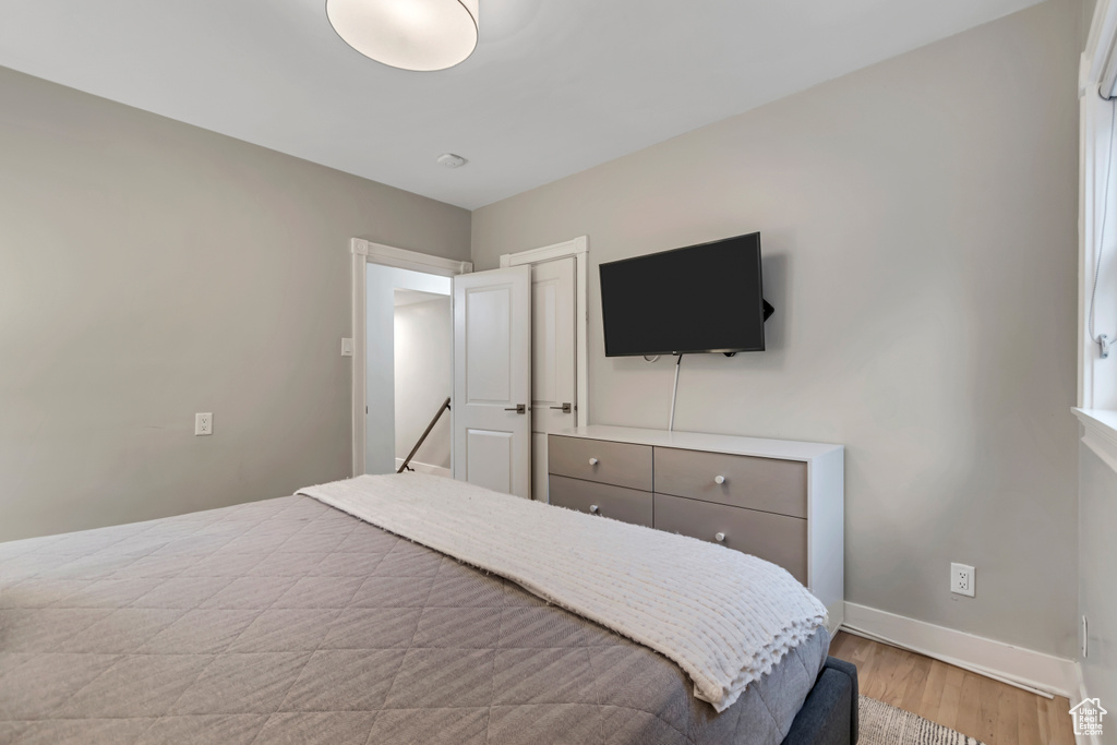 Bedroom with wood finished floors and baseboards