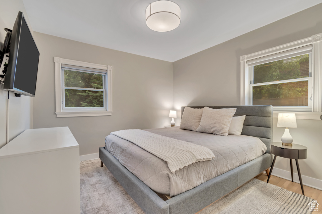 Bedroom with multiple windows and light wood finished floors