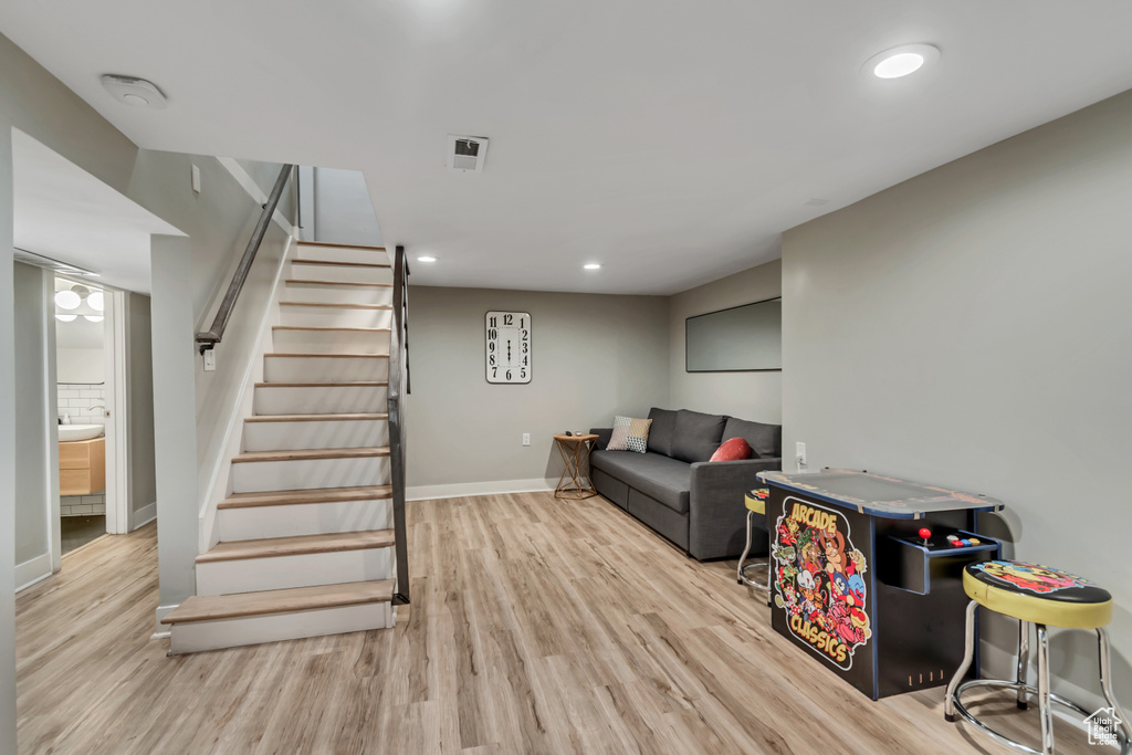 Living room with wood finished floors, stairs, and recessed lighting