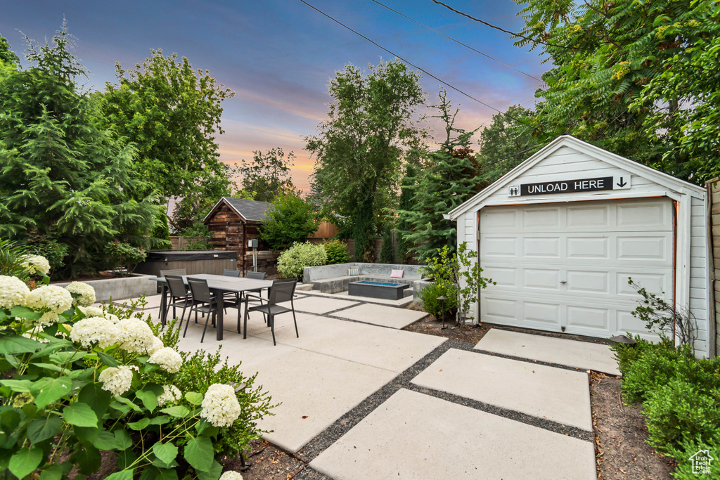 Garage at dusk featuring a garage and driveway