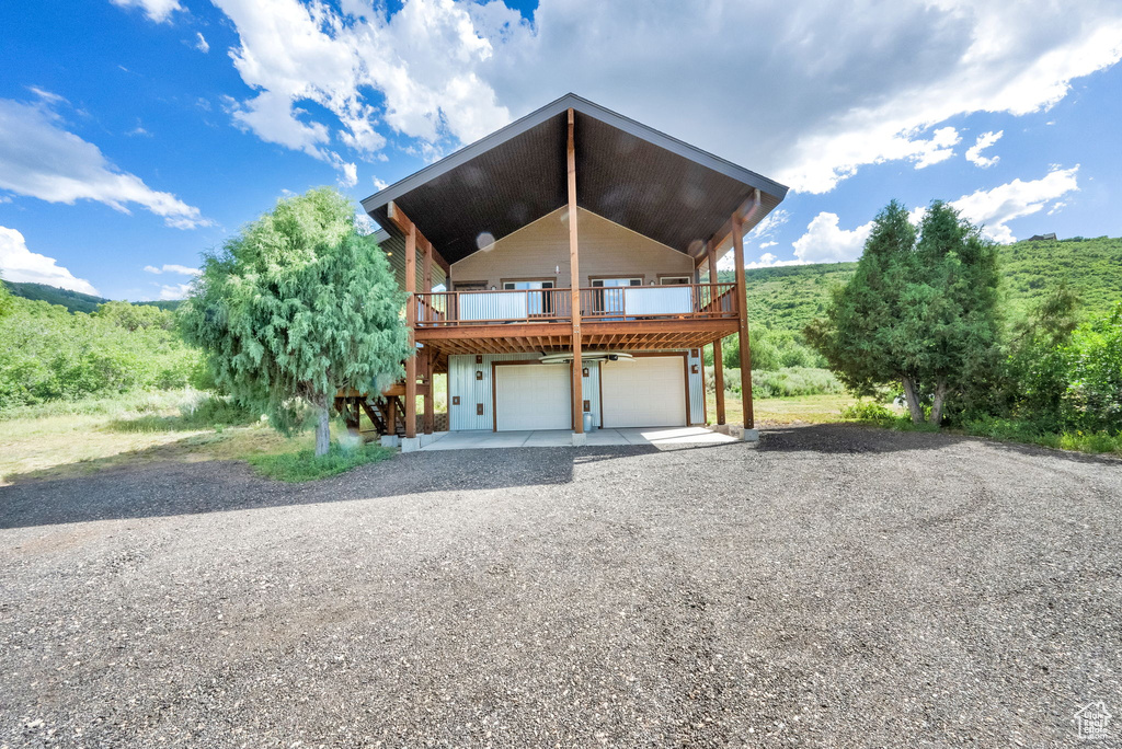 View of front facade with driveway, an attached garage, and a deck