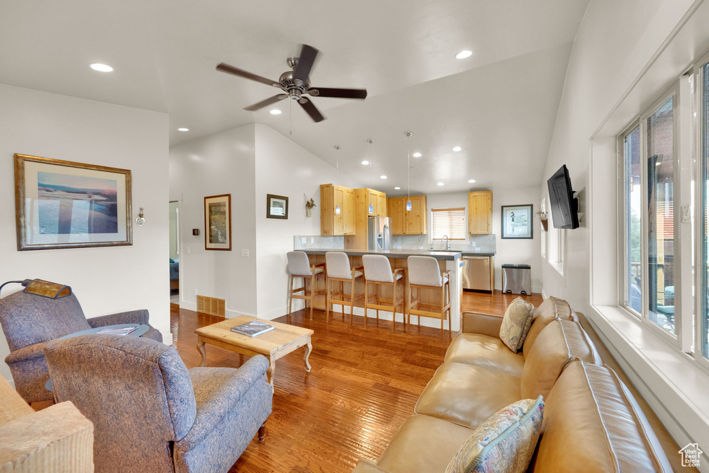 Living area with recessed lighting, light wood-style floors, lofted ceiling, and a ceiling fan