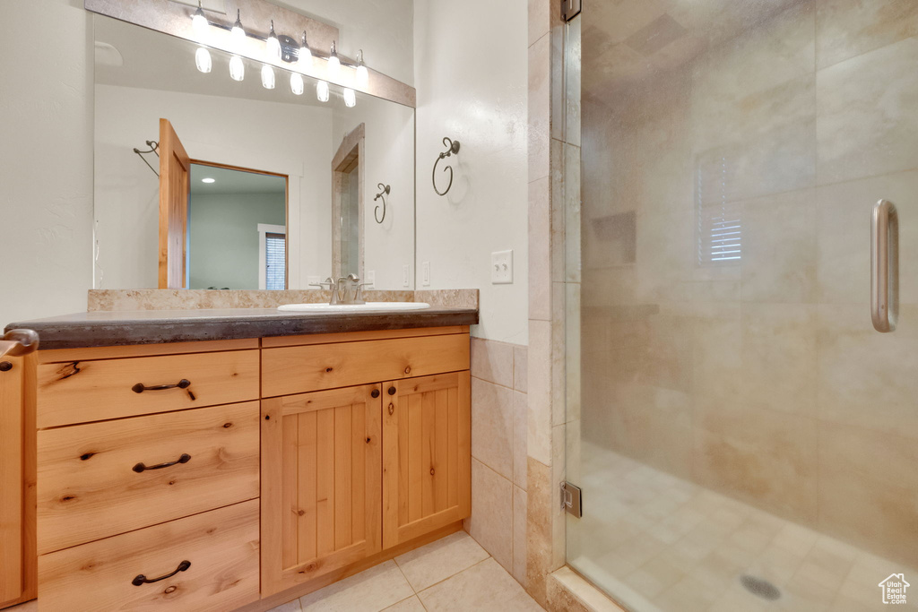Bathroom with vanity, a shower stall, and tile patterned floors