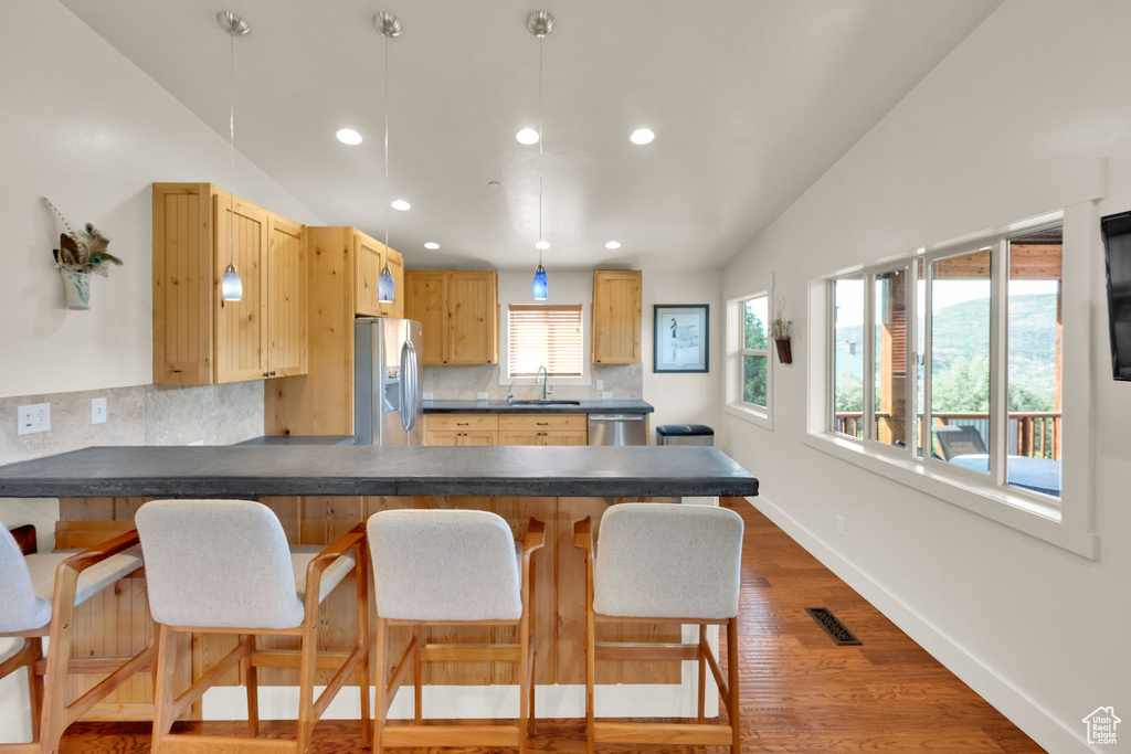 Kitchen with appliances with stainless steel finishes, dark countertops, backsplash, recessed lighting, and a peninsula
