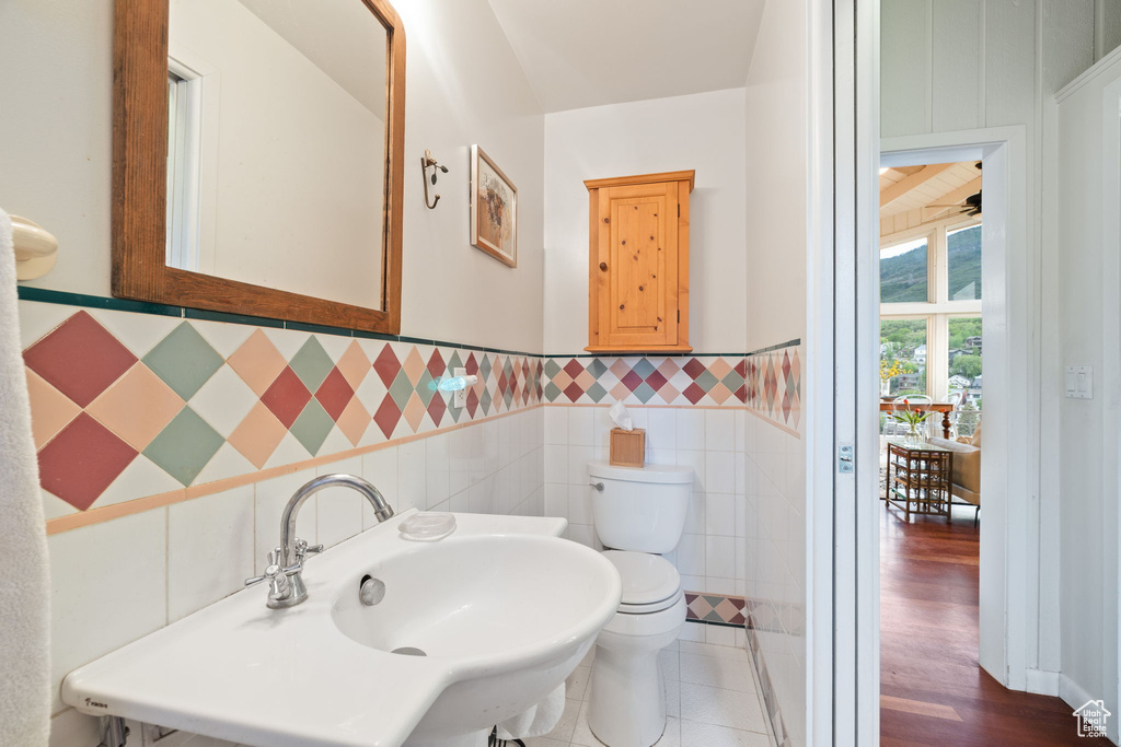 Bathroom with tile walls and a wainscoted wall