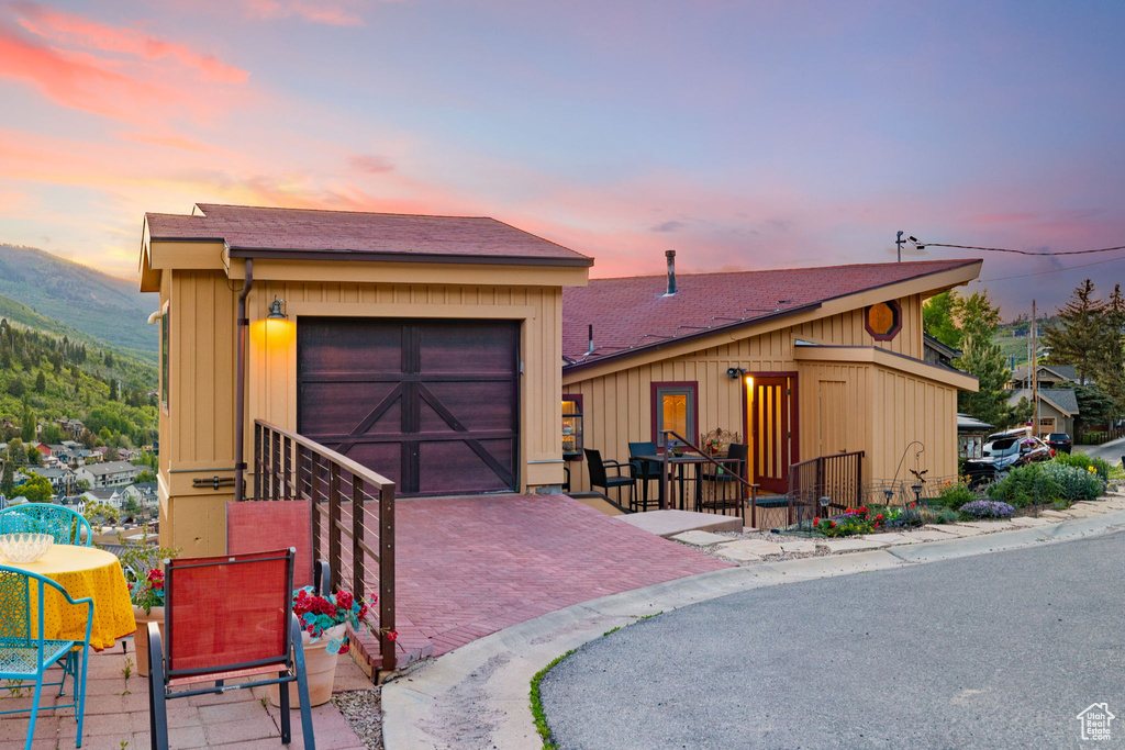 View of front of house featuring a garage, a mountain view, and decorative driveway