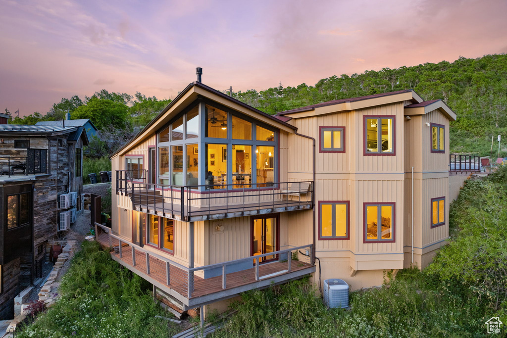 Back of property at dusk with a balcony