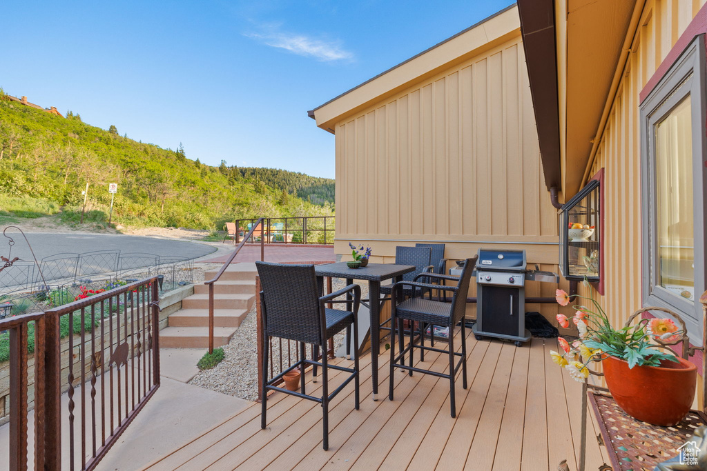 Deck with area for grilling, outdoor dining space, and a mountain view