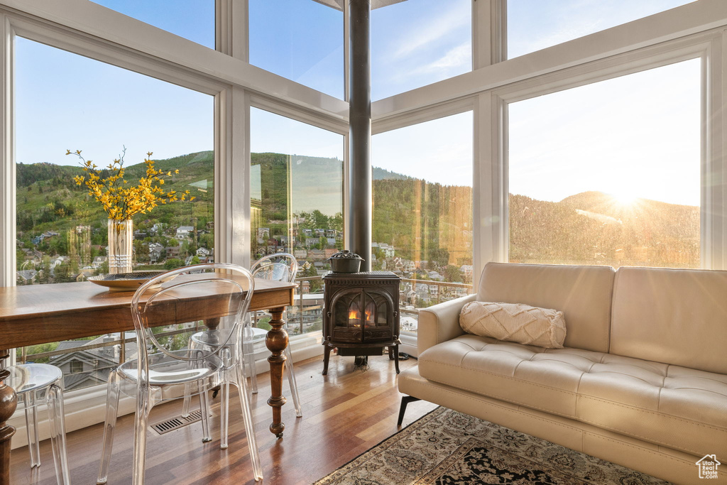 Sunroom featuring a wood stove, wood finished floors, and a mountain view