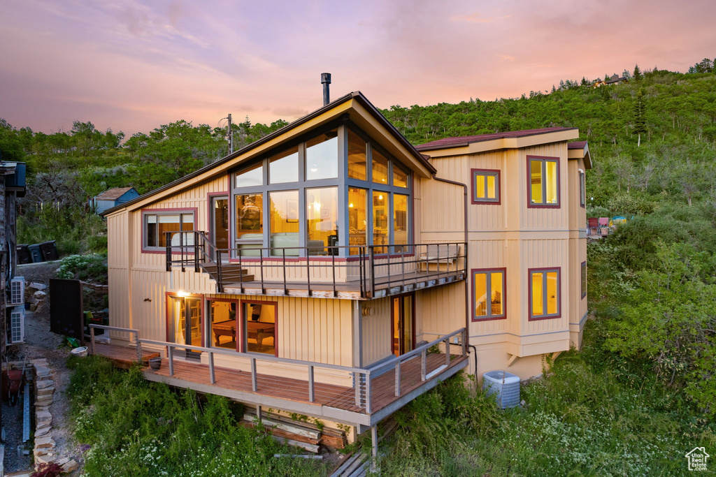 Back of property at dusk with a balcony
