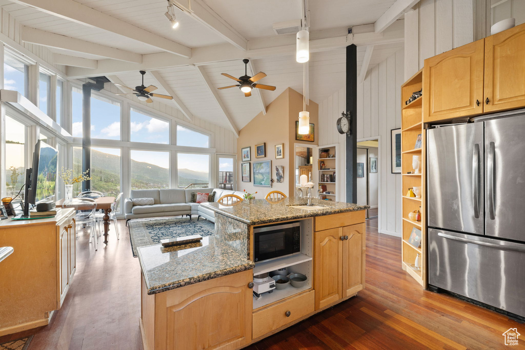 Kitchen featuring appliances with stainless steel finishes, open shelves, track lighting, dark wood-type flooring, and beamed ceiling