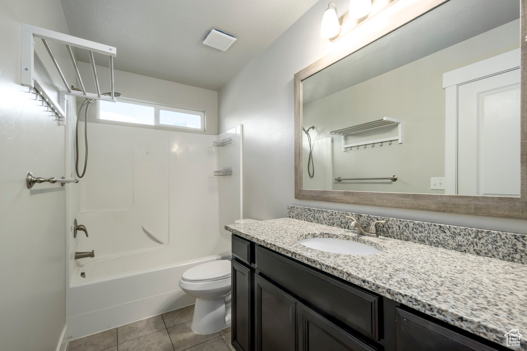 Bathroom with vanity, tub / shower combination, and tile patterned flooring