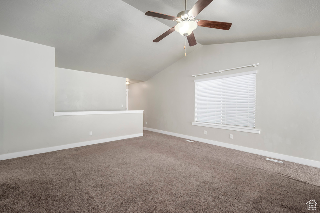 Additional living space with a ceiling fan, carpet, and lofted ceiling