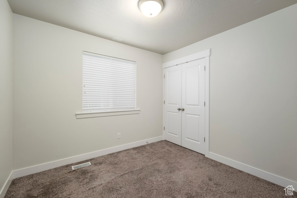 Unfurnished bedroom with carpet floors and a closet