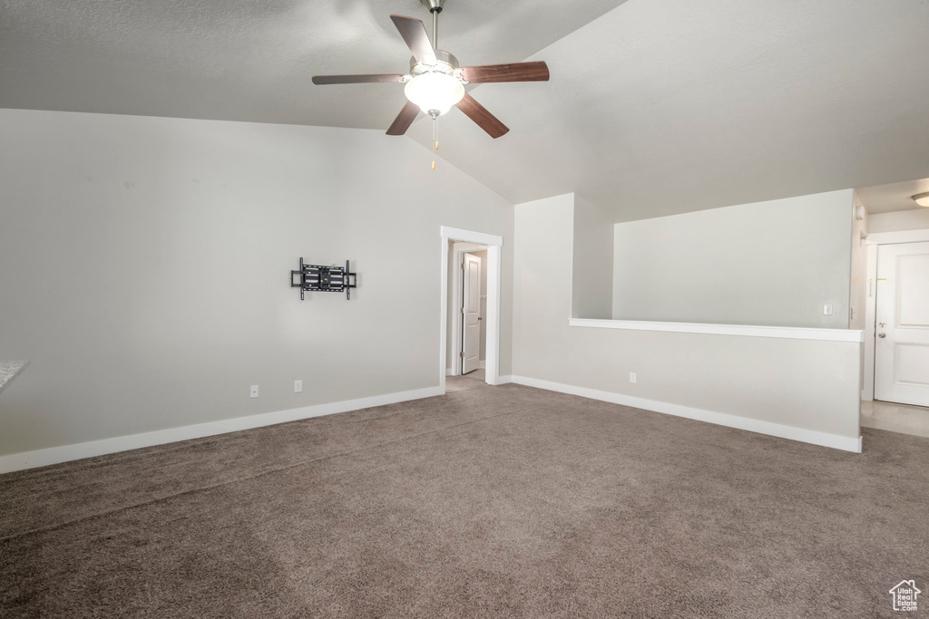 Unfurnished room featuring a ceiling fan, lofted ceiling, and carpet floors