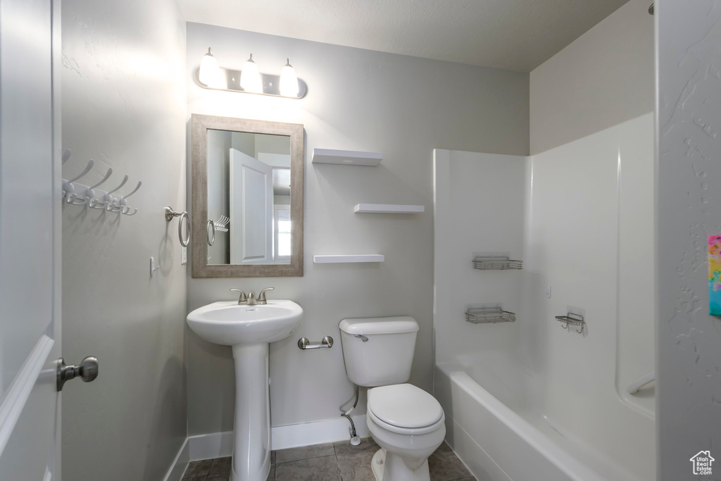 Full bath with tile patterned floors and shower / washtub combination