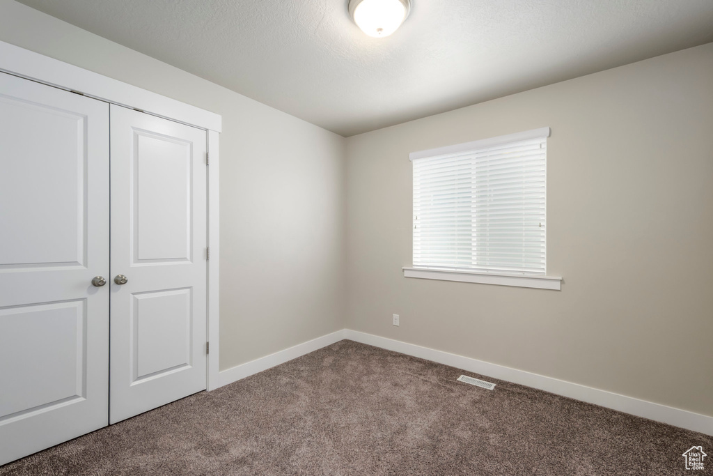 Unfurnished bedroom with carpet and a closet