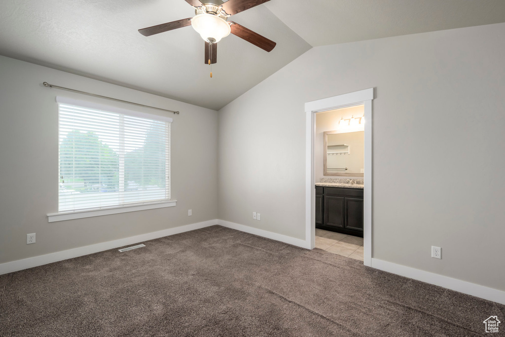 Unfurnished room featuring lofted ceiling, a ceiling fan, and light colored carpet