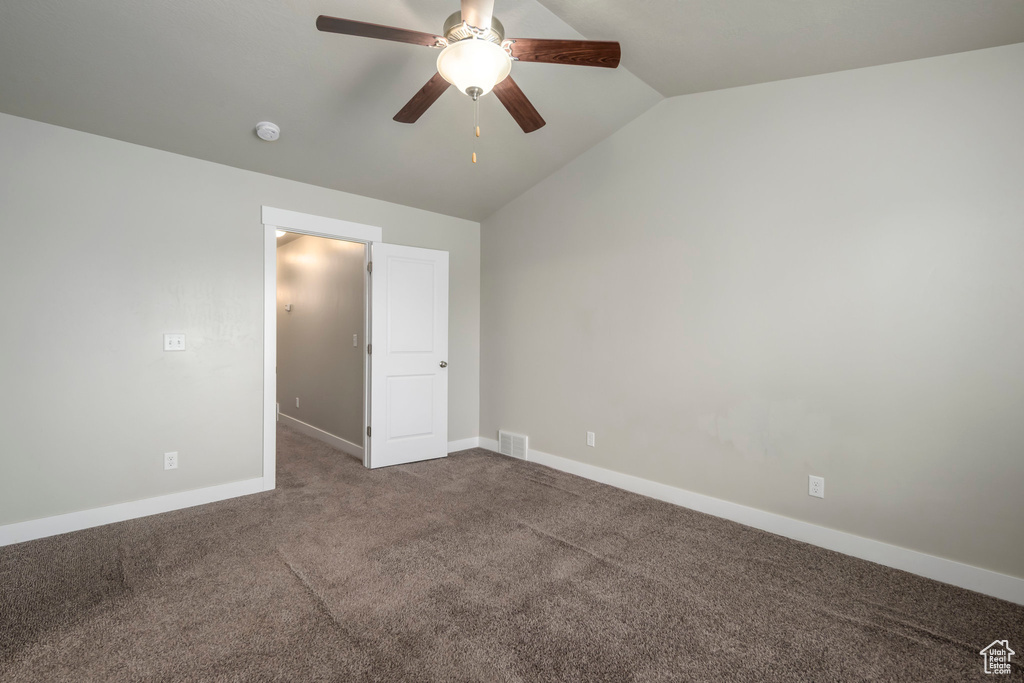 Unfurnished bedroom featuring vaulted ceiling, carpet flooring, and ceiling fan