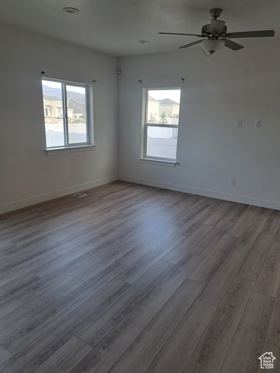 Empty room featuring wood finished floors and a ceiling fan