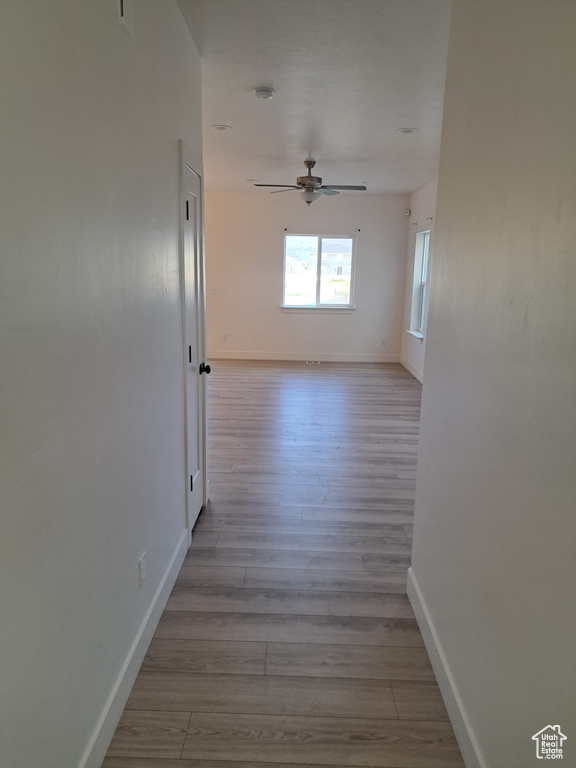 Hallway with wood finished floors and baseboards