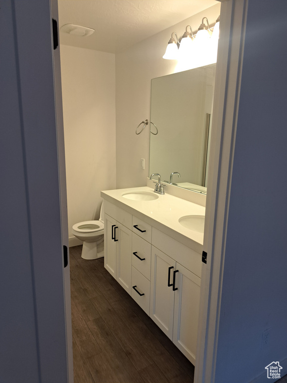 Full bath with double vanity and wood finished floors