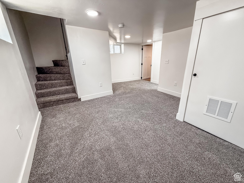 Basement with carpet, recessed lighting, and stairway