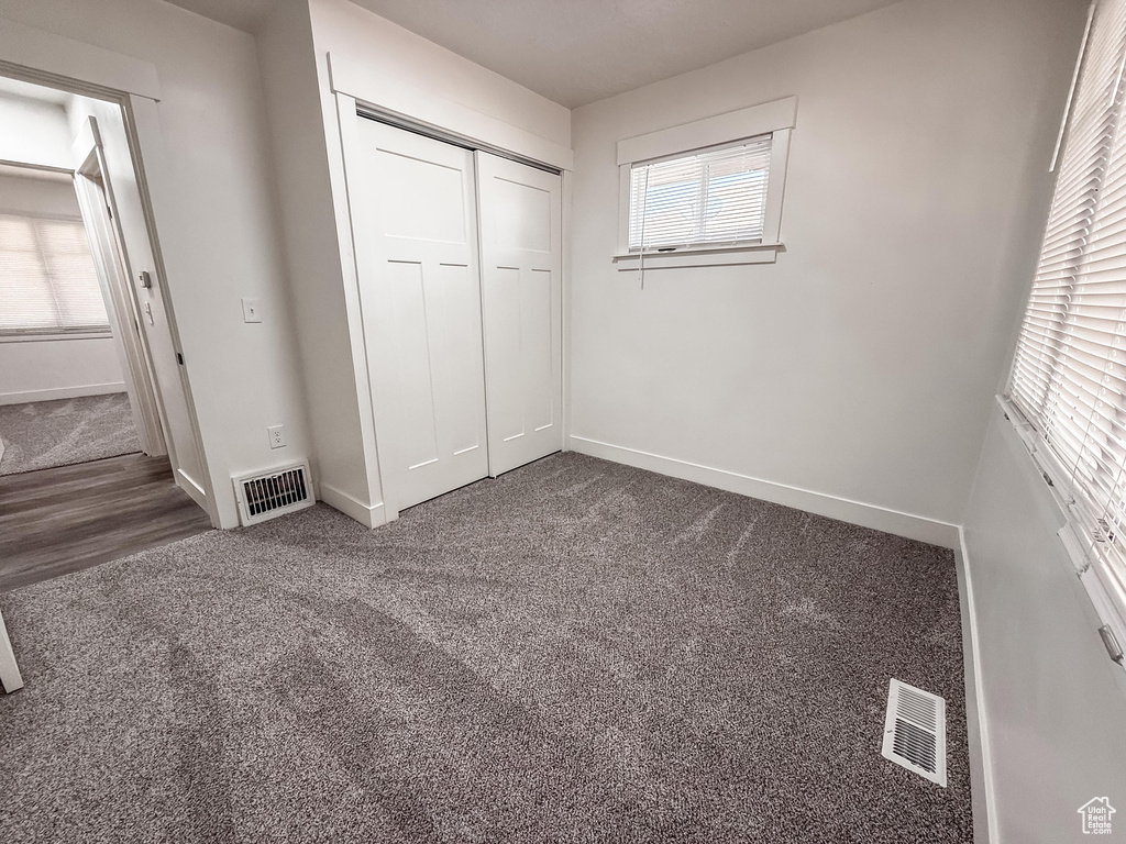 Unfurnished bedroom featuring a closet and carpet floors