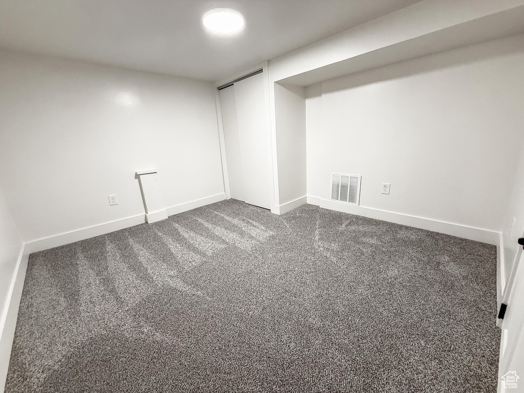 Finished basement featuring dark carpet and baseboards