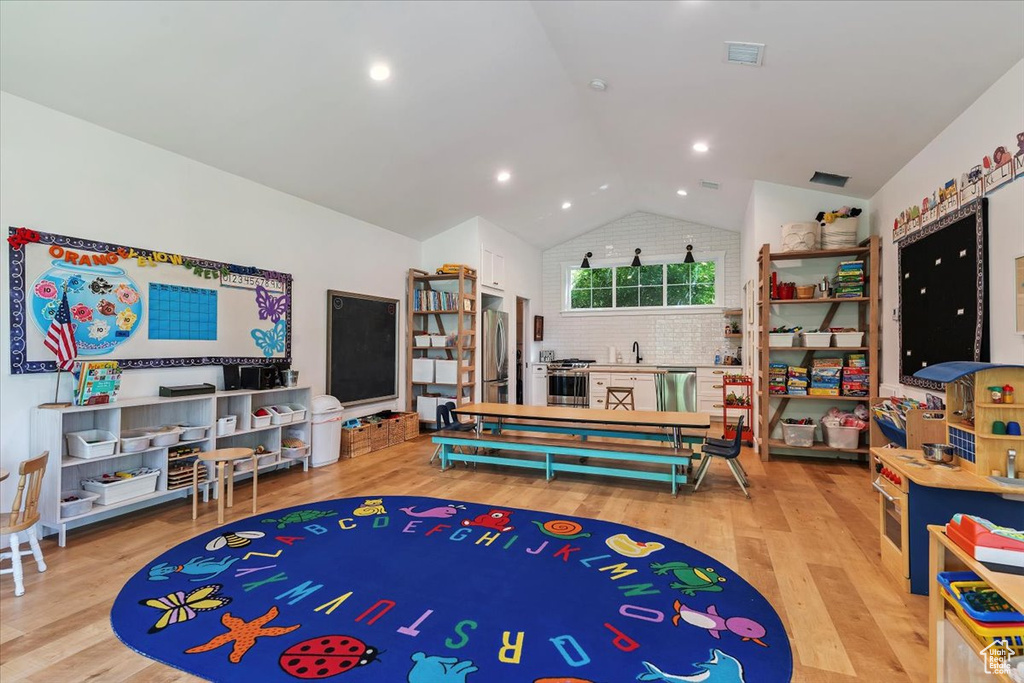 Recreation room featuring vaulted ceiling and wood finished floors