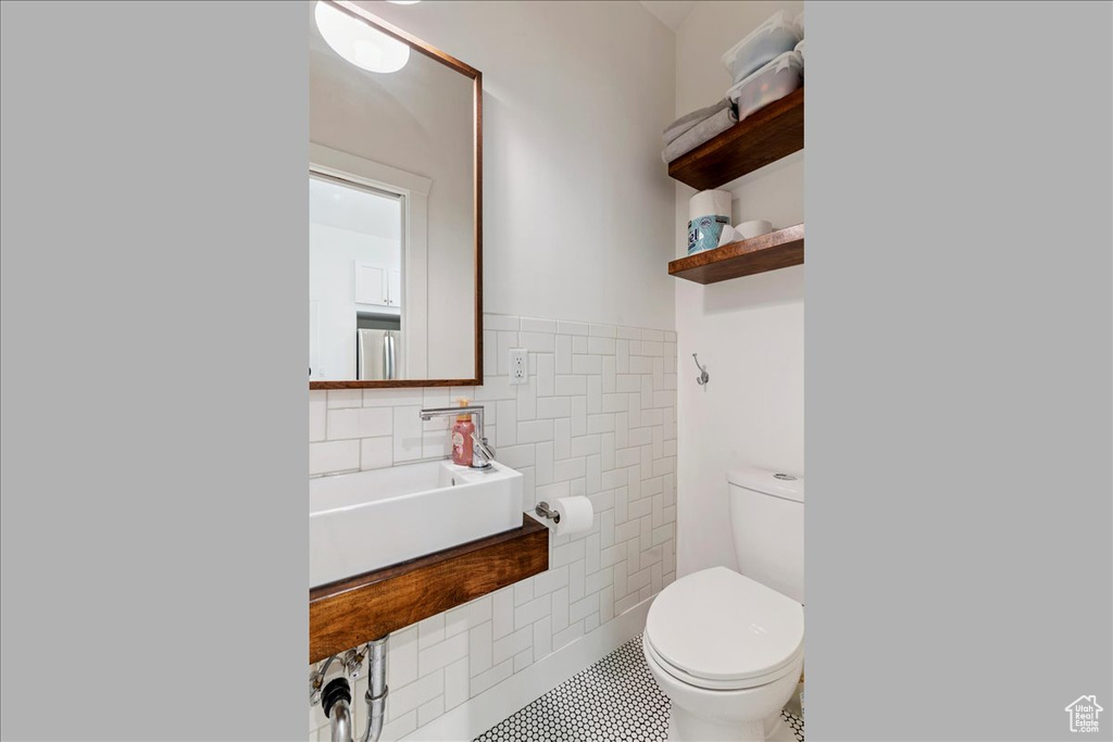Bathroom featuring tile walls and a wainscoted wall