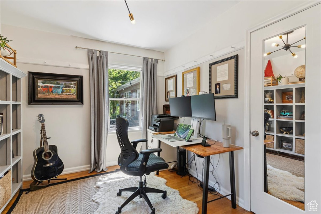 Home office featuring wood finished floors and a chandelier