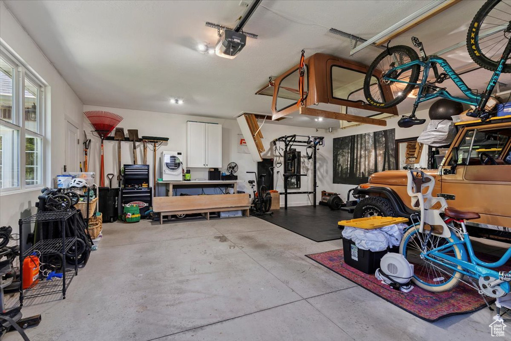 Garage featuring a garage door opener and washer / dryer