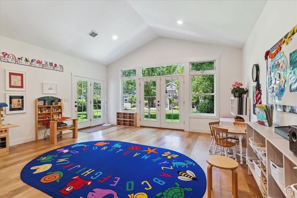 Game room featuring french doors, wood finished floors, and high vaulted ceiling