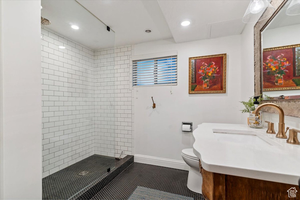 Bathroom with a tile shower, vanity, recessed lighting, and tile patterned floors