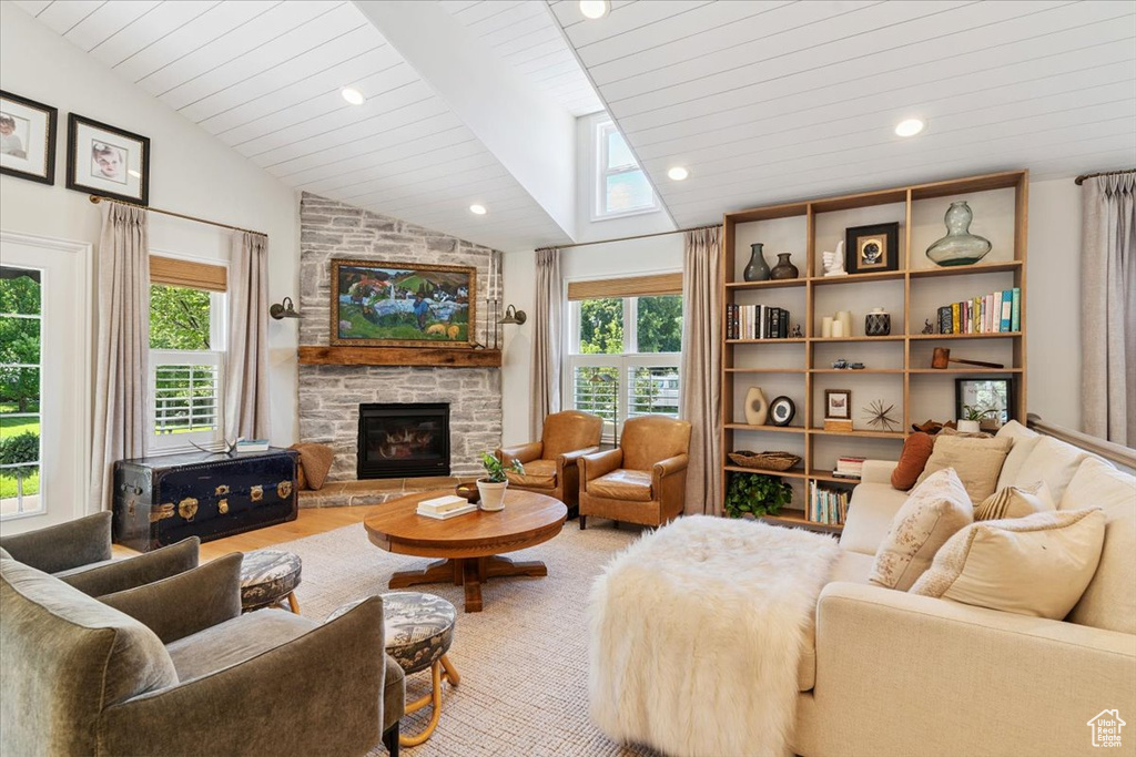 Living area featuring a fireplace, a skylight, recessed lighting, and wood ceiling