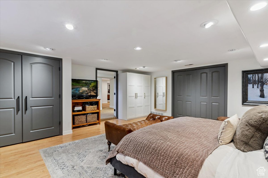 Bedroom with light wood-style flooring, multiple closets, and recessed lighting