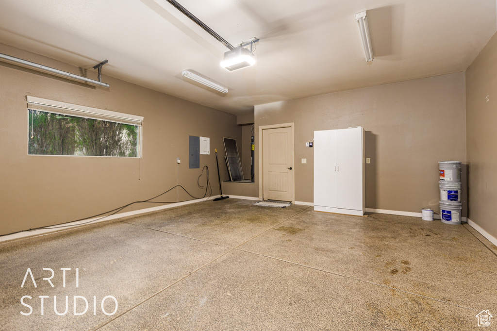 Garage featuring electric panel and a garage door opener