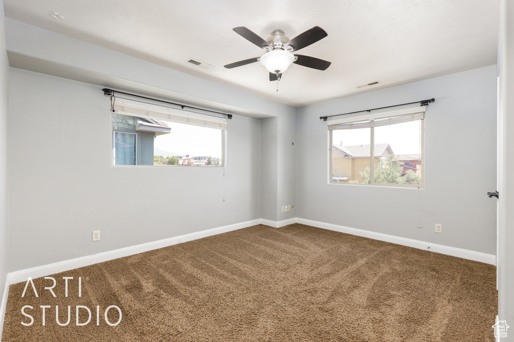 Carpeted empty room with baseboards and ceiling fan