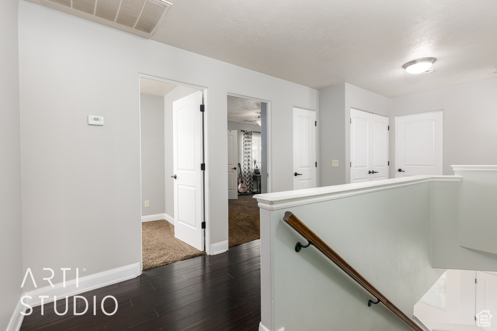 Hallway with an upstairs landing and dark wood finished floors